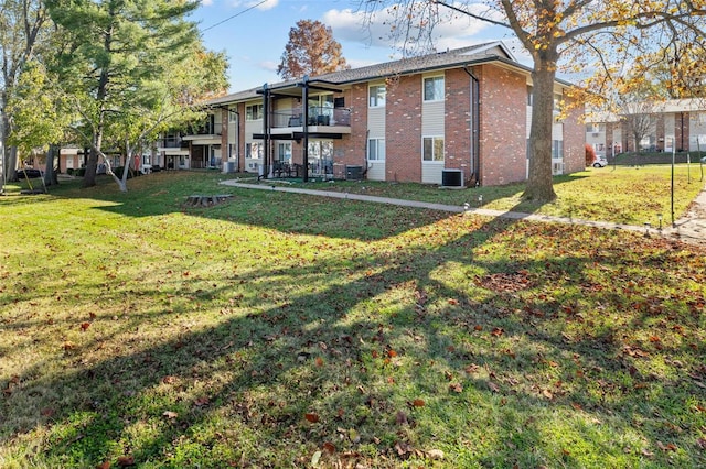 back of property featuring a balcony, a yard, and cooling unit