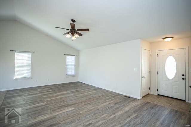 foyer entrance featuring lofted ceiling, plenty of natural light, dark wood-type flooring, and ceiling fan