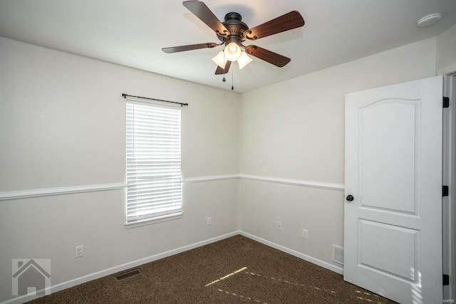 unfurnished room featuring dark colored carpet and ceiling fan