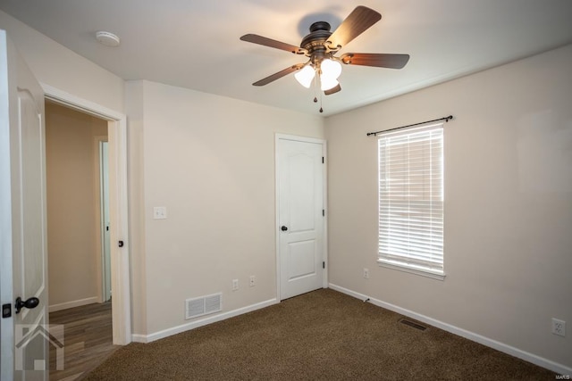 unfurnished bedroom featuring dark colored carpet and ceiling fan