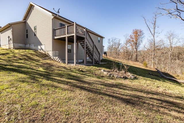 rear view of property featuring a lawn and a wooden deck