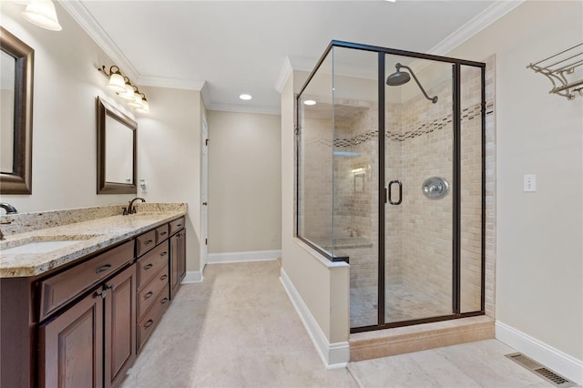 bathroom with a shower with door, vanity, and ornamental molding