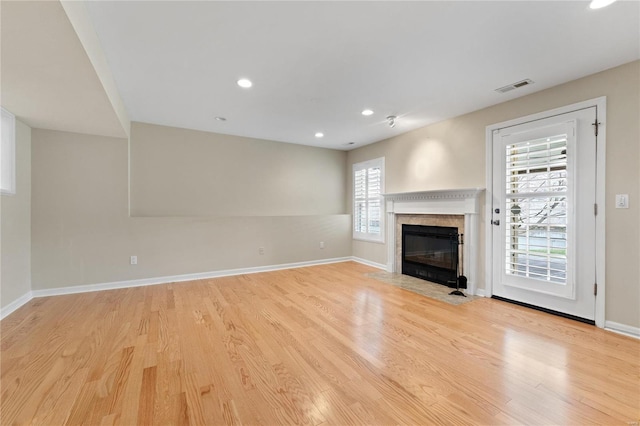 unfurnished living room featuring plenty of natural light and light hardwood / wood-style flooring