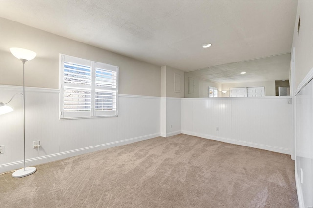 empty room featuring a textured ceiling and light carpet