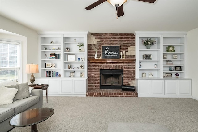 living area with a ceiling fan, a brick fireplace, and carpet