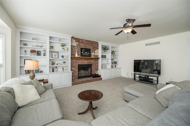 carpeted living area featuring visible vents, a fireplace, a ceiling fan, and built in shelves