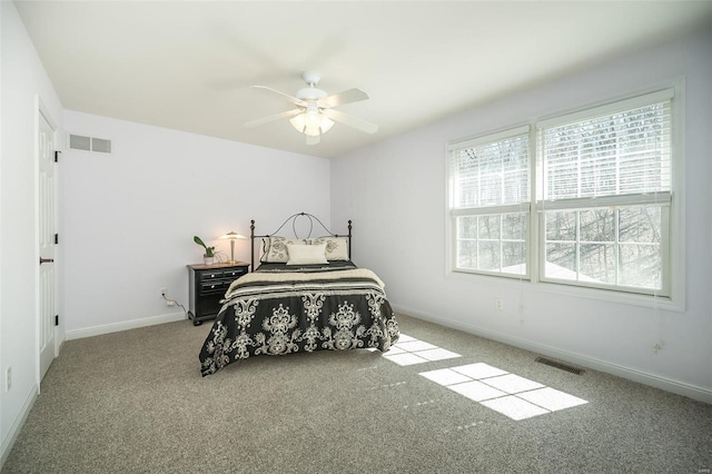 carpeted bedroom with visible vents, a ceiling fan, and baseboards