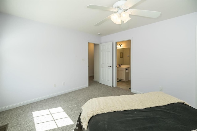 bedroom featuring connected bathroom, baseboards, light colored carpet, and a ceiling fan