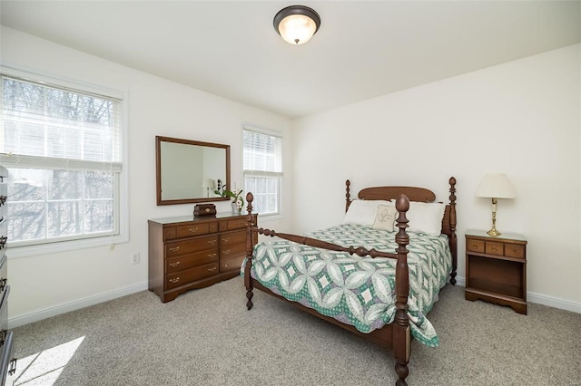 bedroom featuring light colored carpet and baseboards