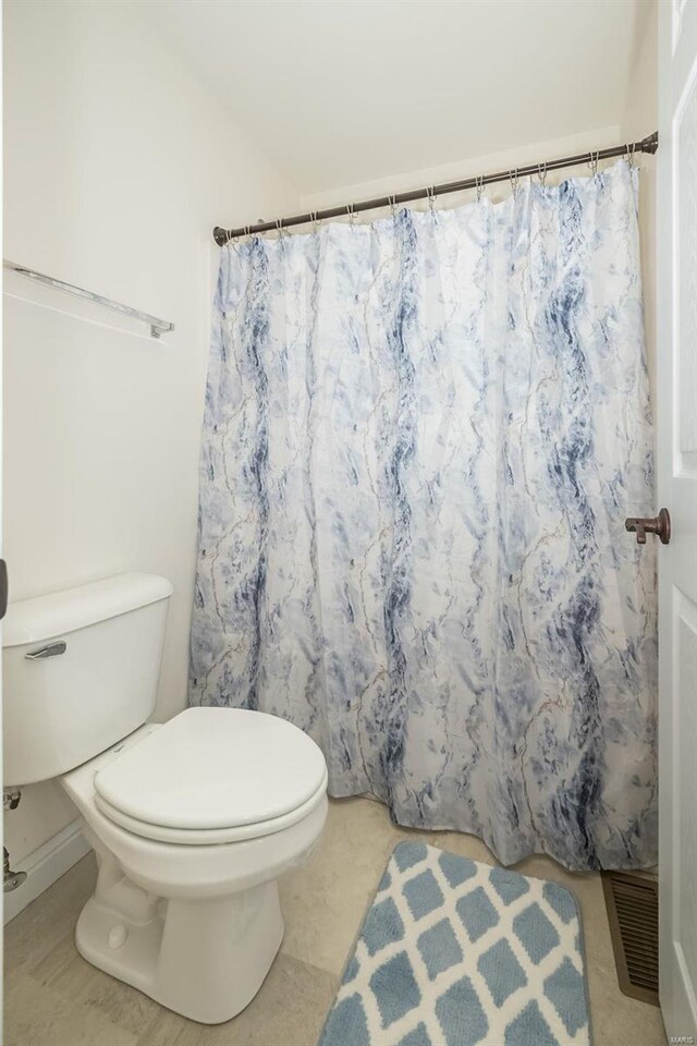 bathroom with a shower with curtain, toilet, and visible vents