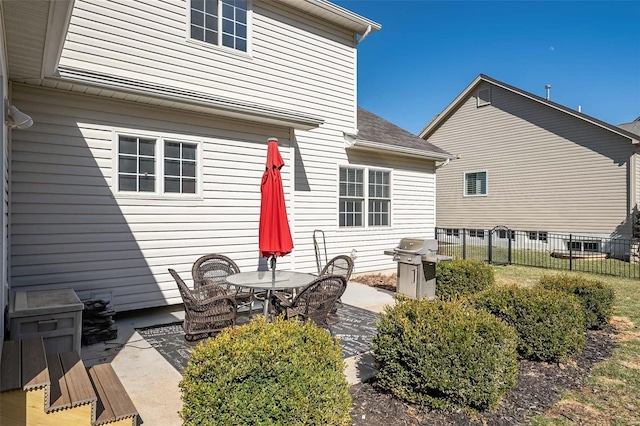 rear view of property featuring a patio and fence