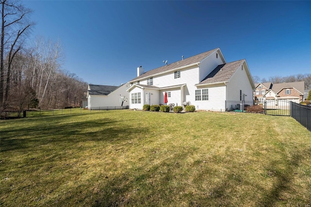 rear view of house with a lawn, a fenced backyard, and a chimney