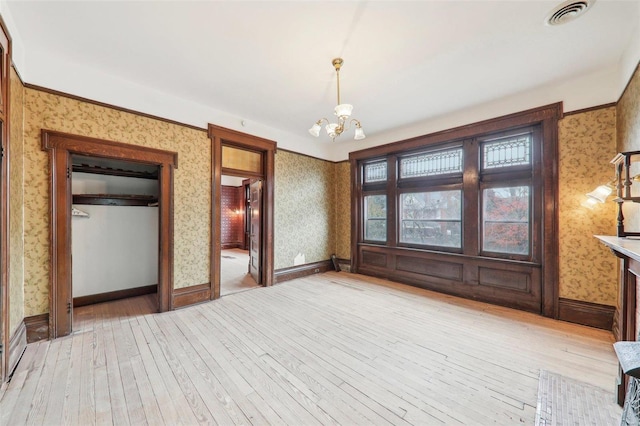 unfurnished bedroom with light hardwood / wood-style floors, an inviting chandelier, and a closet