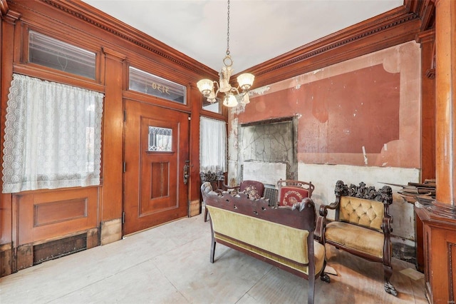 foyer entrance featuring an inviting chandelier and crown molding