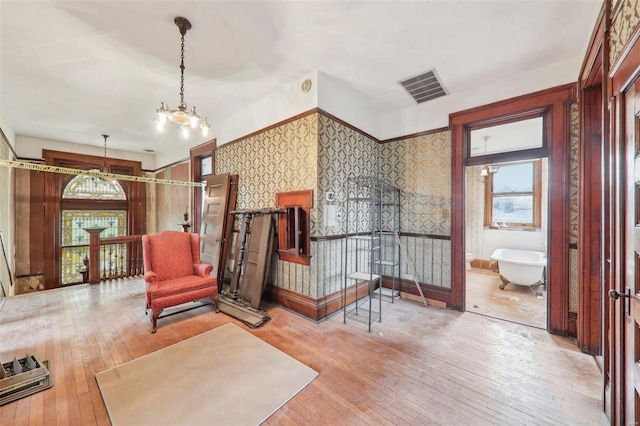 sitting room featuring light wood-type flooring and a notable chandelier