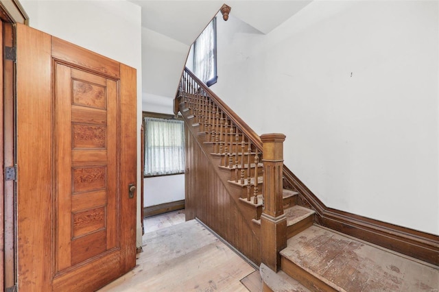 stairs featuring plenty of natural light and hardwood / wood-style floors