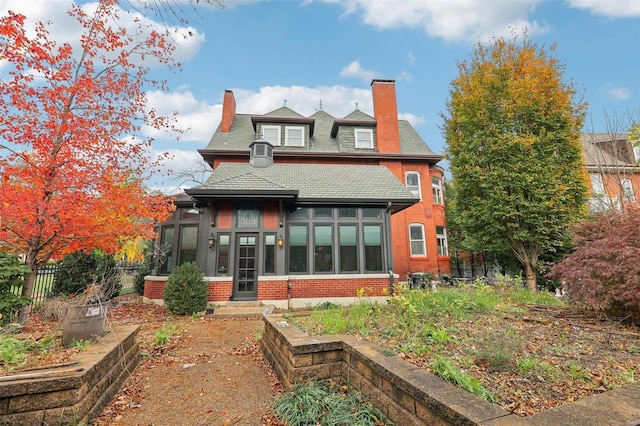 rear view of property with a sunroom