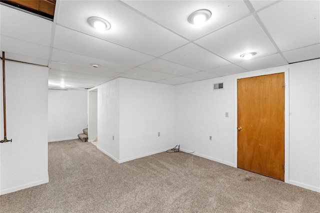 basement with a paneled ceiling and carpet floors