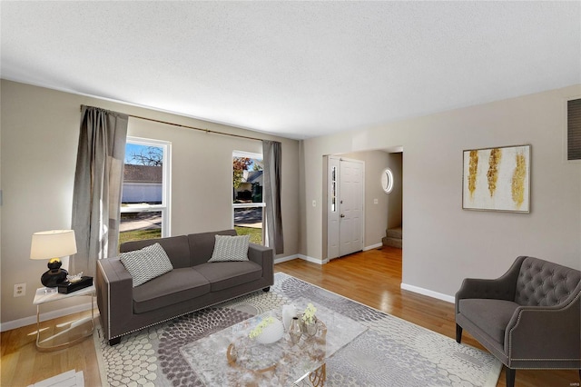 living room featuring wood-type flooring and a textured ceiling