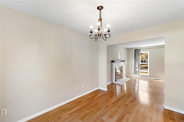 unfurnished living room with light hardwood / wood-style flooring and a chandelier