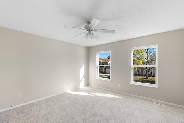 empty room featuring ceiling fan and light carpet