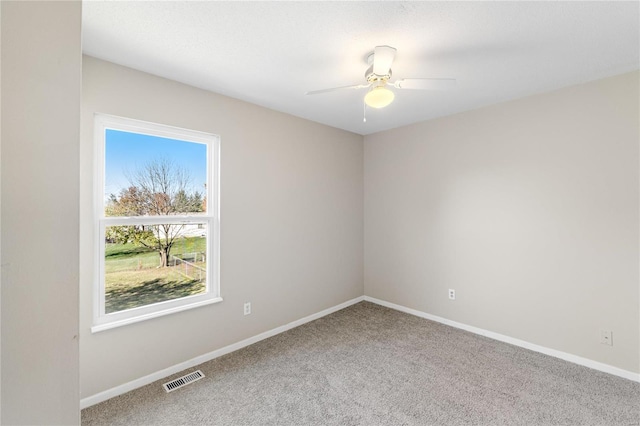 carpeted empty room featuring ceiling fan and a healthy amount of sunlight