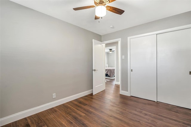 unfurnished bedroom with dark hardwood / wood-style flooring, a closet, and ceiling fan