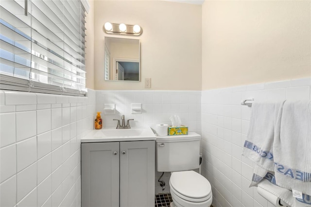 bathroom featuring tile walls, vanity, and toilet