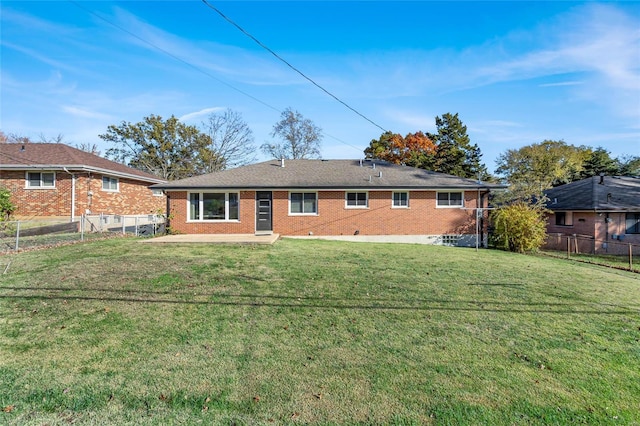 rear view of property featuring a patio and a yard