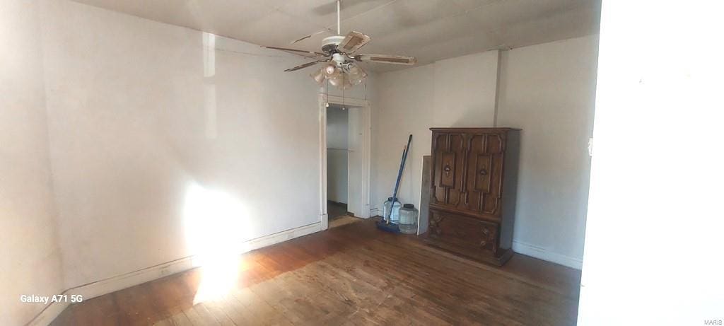 unfurnished room with dark wood-type flooring and ceiling fan