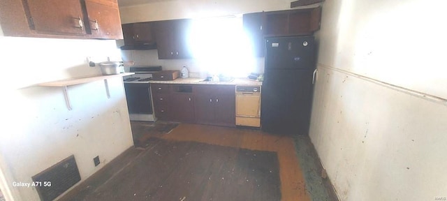 kitchen with dark brown cabinets, dark hardwood / wood-style flooring, sink, and oven