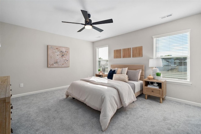 carpeted bedroom with ceiling fan and multiple windows