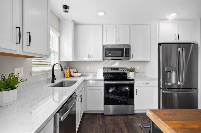 kitchen with dark wood-type flooring, white cabinetry, appliances with stainless steel finishes, and sink