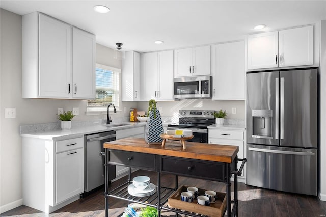 kitchen with dark hardwood / wood-style flooring, white cabinetry, appliances with stainless steel finishes, and sink