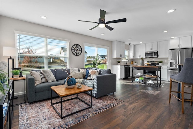 living room featuring dark wood-type flooring and ceiling fan