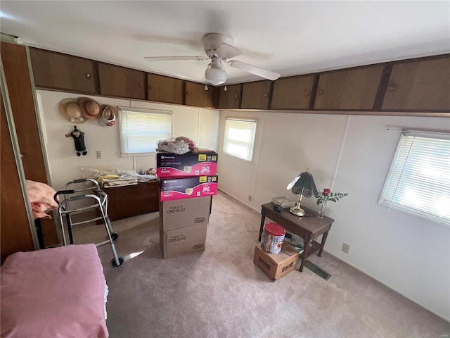 interior space featuring ceiling fan and light colored carpet