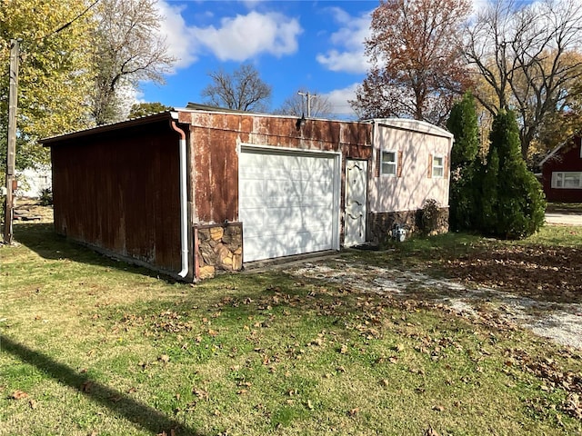 view of outbuilding with a lawn and a garage