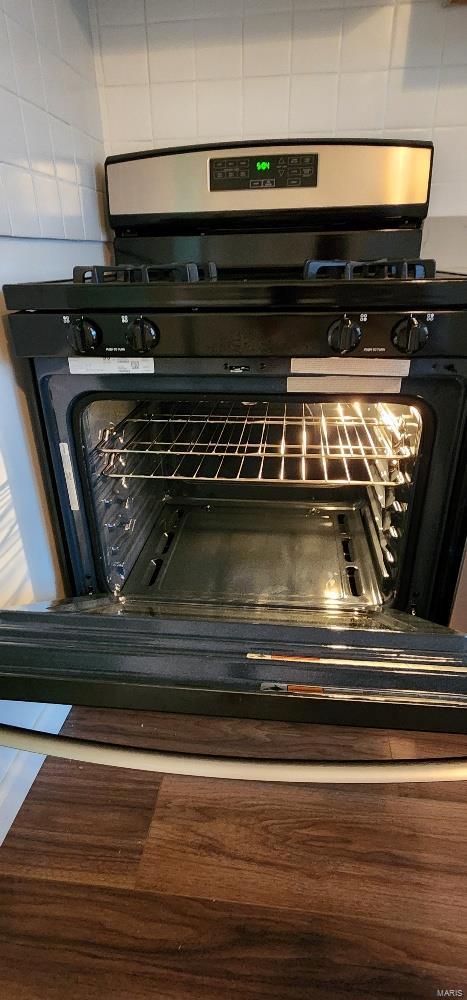 room details with decorative backsplash and gas stove