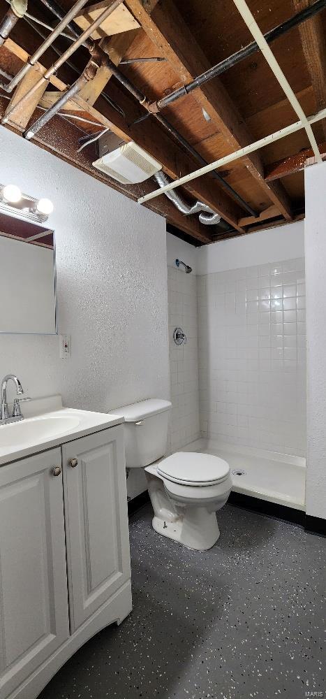 bathroom featuring walk in shower, vanity, and toilet