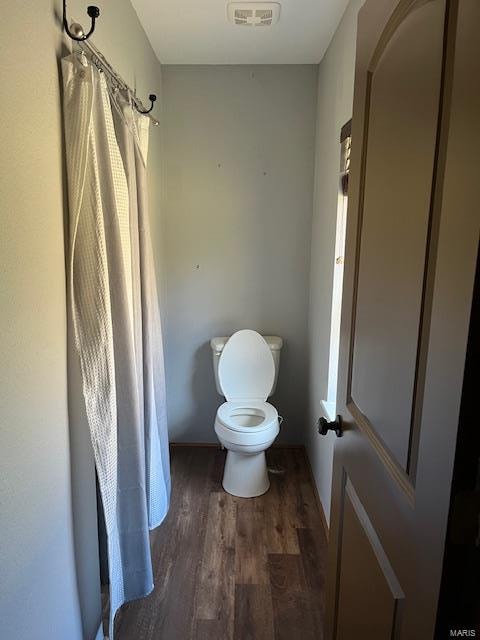 bathroom with toilet and hardwood / wood-style flooring