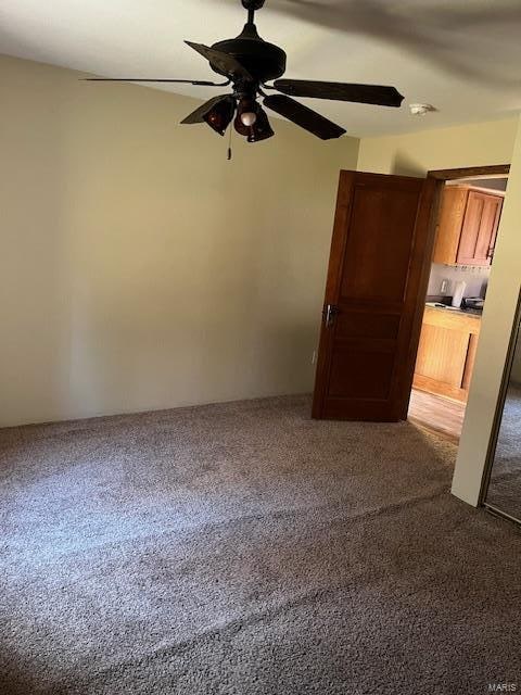 unfurnished room with carpet and ceiling fan