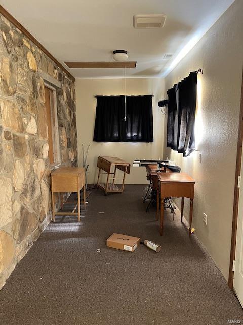 miscellaneous room featuring dark colored carpet