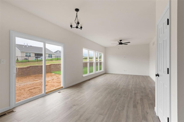 interior space featuring ceiling fan with notable chandelier and light hardwood / wood-style floors