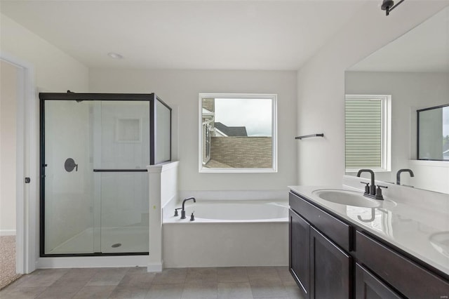 bathroom with vanity and shower with separate bathtub