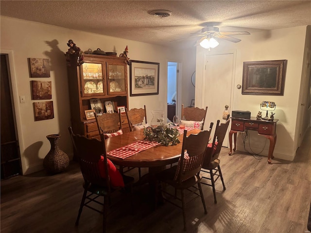 dining area with hardwood / wood-style floors, a textured ceiling, and ceiling fan