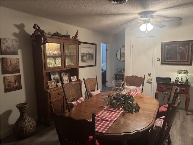 dining area with a textured ceiling, hardwood / wood-style flooring, and ceiling fan