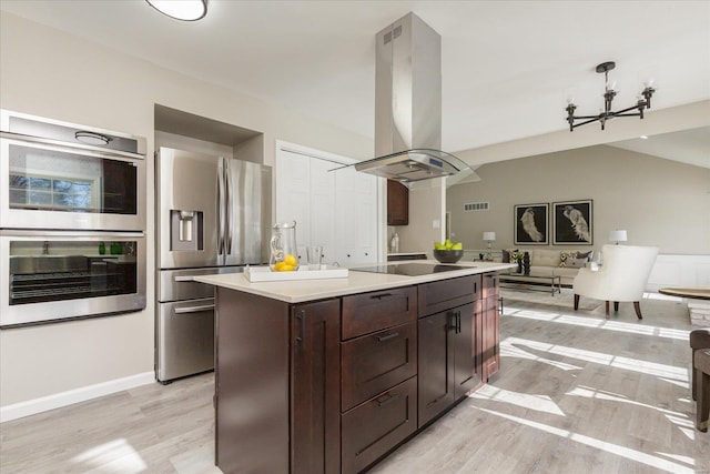 kitchen with appliances with stainless steel finishes, a center island, island range hood, light wood-type flooring, and dark brown cabinets