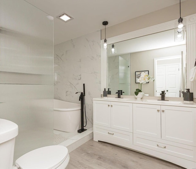 bathroom featuring vanity, wood-type flooring, and a bath