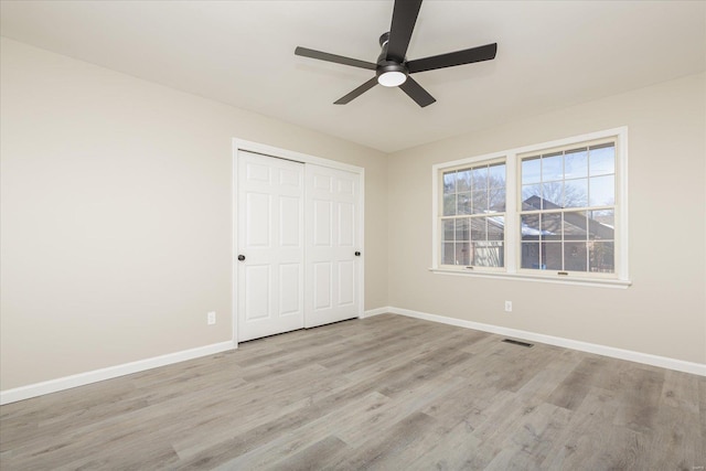 unfurnished bedroom featuring ceiling fan, a closet, and light wood-type flooring