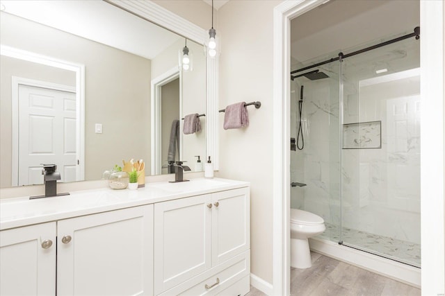 bathroom featuring vanity, toilet, wood-type flooring, and an enclosed shower